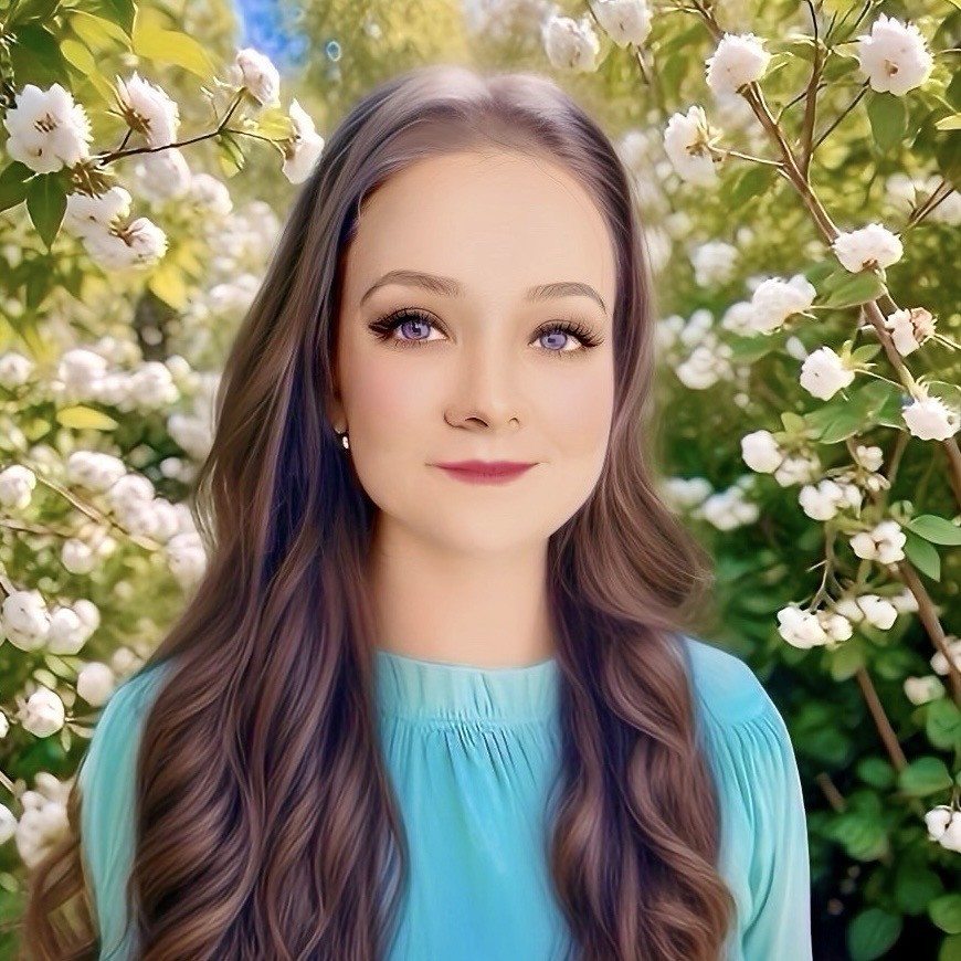 Julie McKenzie outdoors amidst white flowers and green foliage